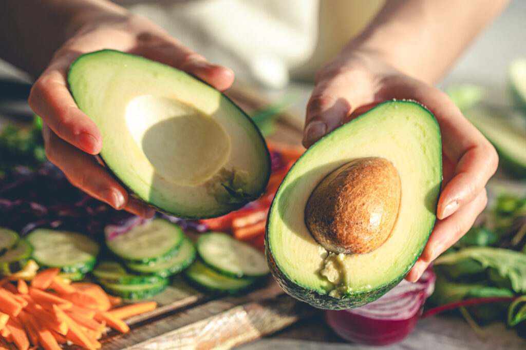 Close-up of a cut avocado in a woman's hands